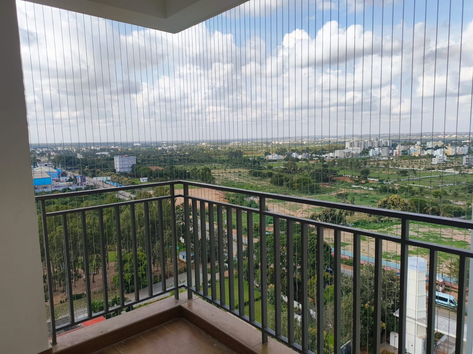 Professional invisible grill on a high-rise balcony with open green city view